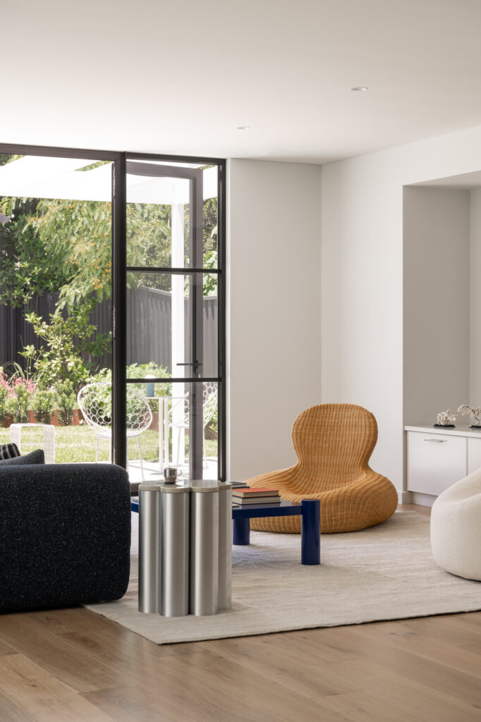 Designer chair in light bright living space opening into the garden